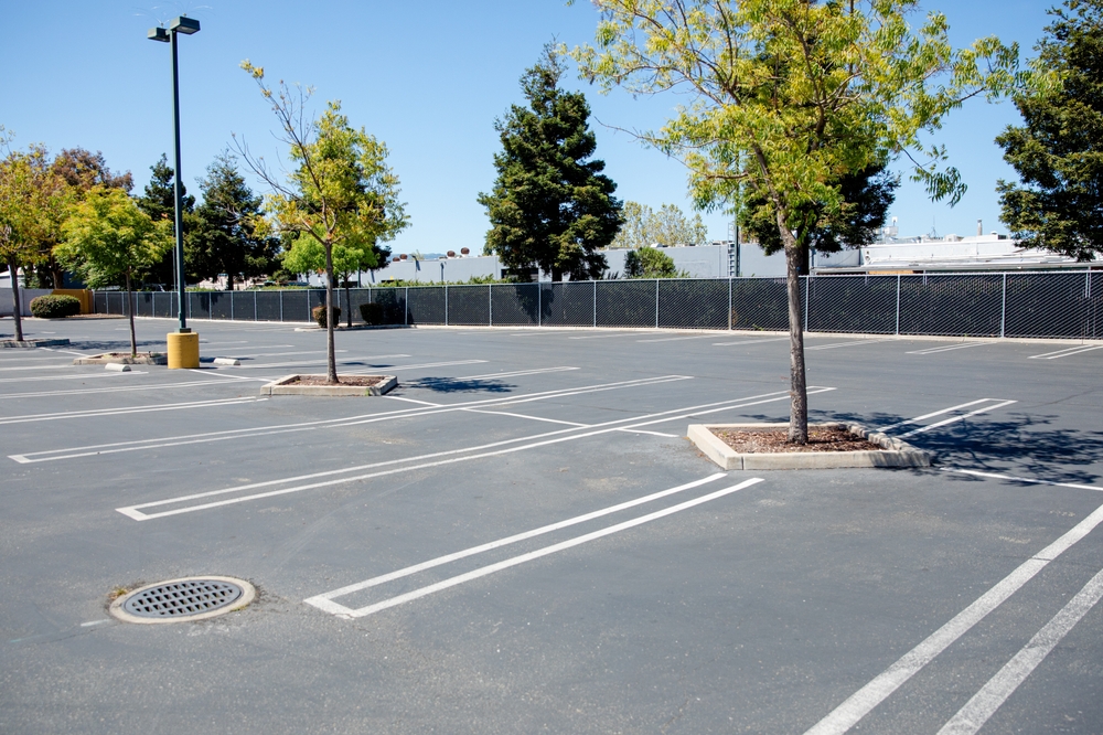 Empty,concrete,parking,lot,in,the,city,with,white,markings